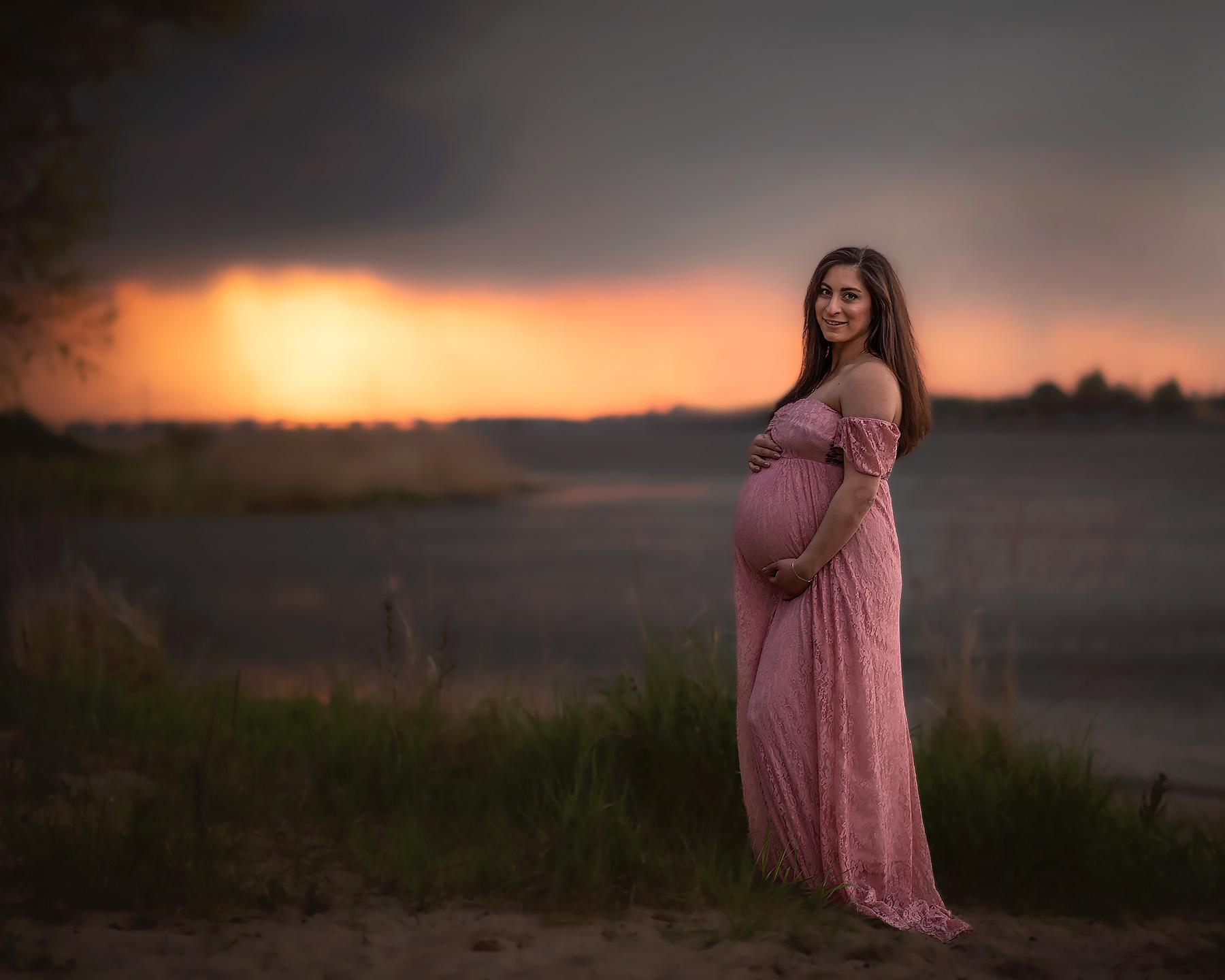 Zwangere vrouw bij ondergaande zon